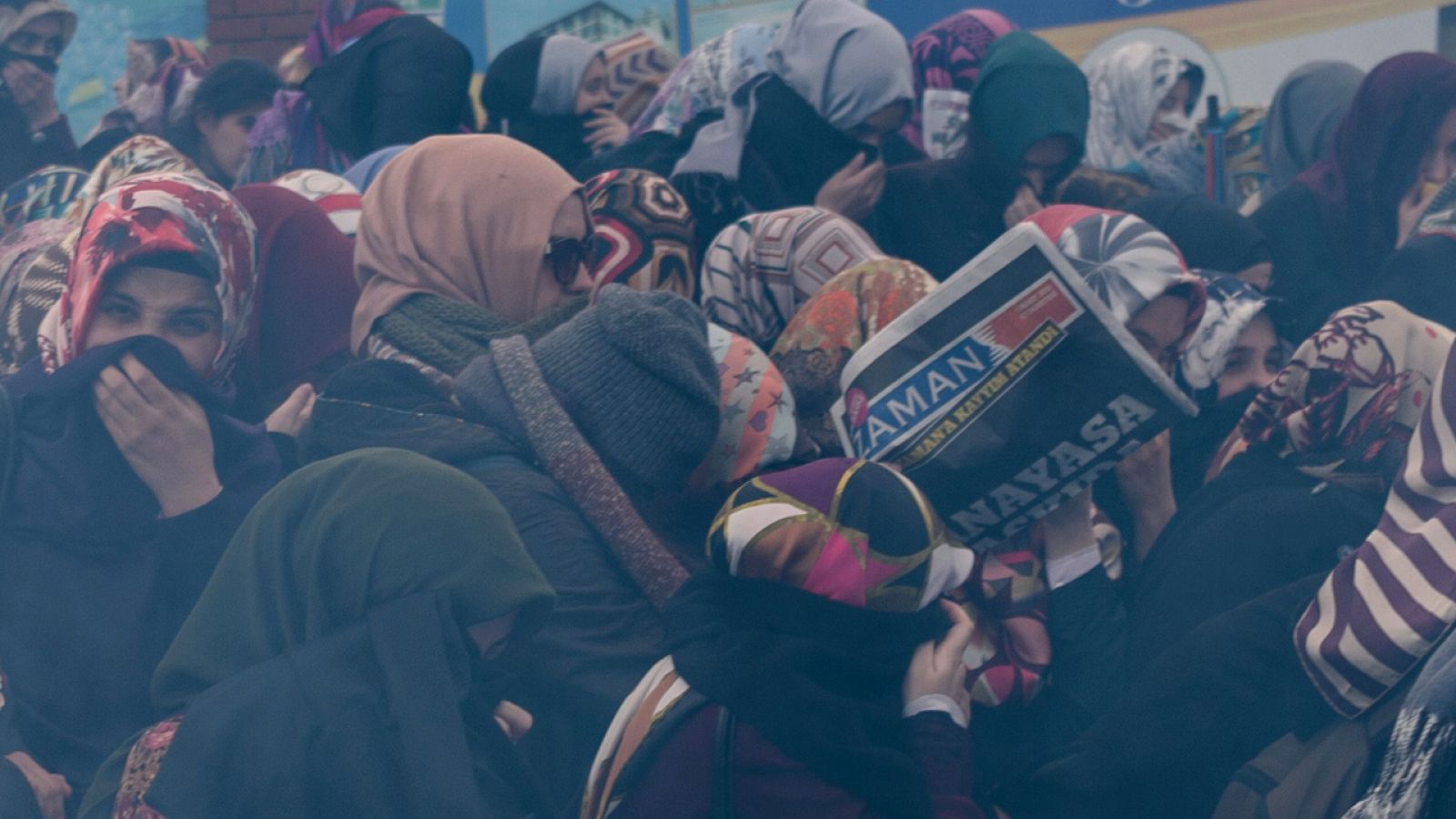 Mujeres turcas se cubren el rostro para protegerse del gas lacrimógeno lanzado por la policía turca en una manifestación frente a las oficinas del diario Zaman