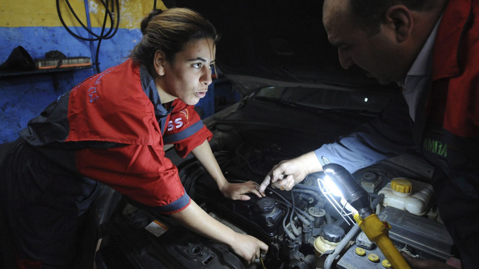 Una joven mecánica marroquí arregla un coche en un taller