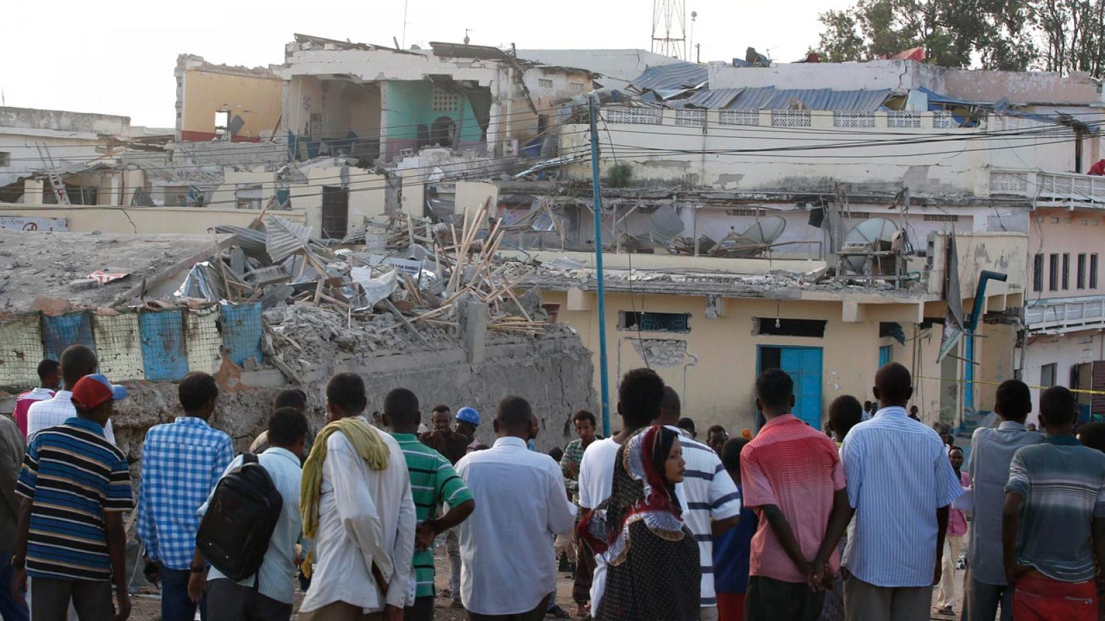 Un grupo de somalíes observan el destrozo causado por un coche bomba de Al Shabab en un hotel de Mogadiscio, a finales de febrero