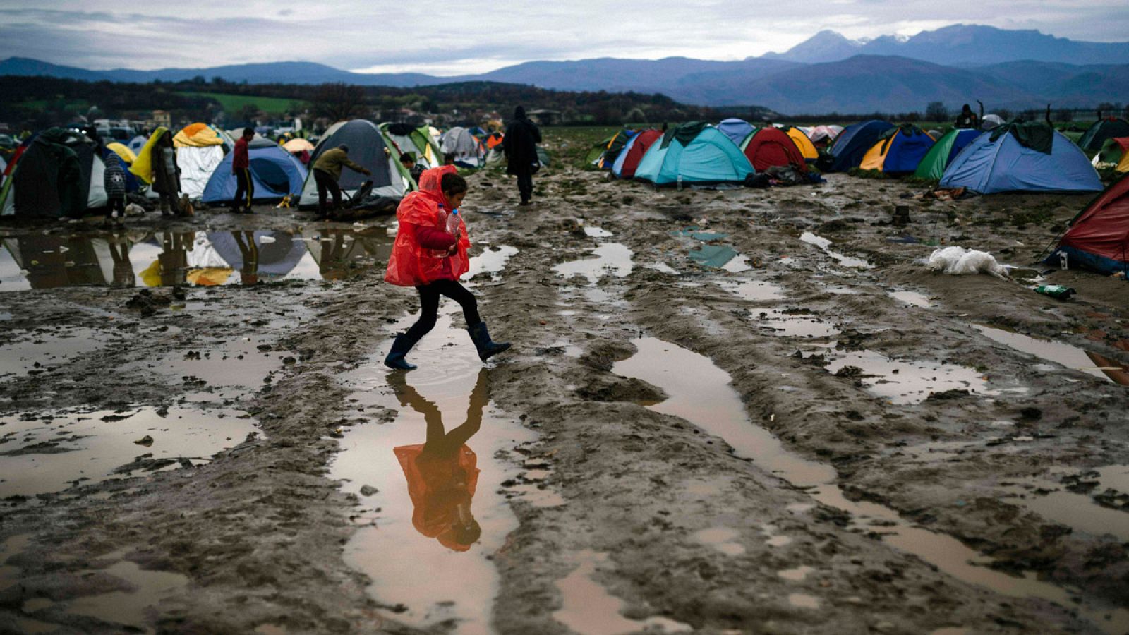 Una niña camina por el barro en un asentamiento de refugiados en la frontera entre Grecia y Macedonia