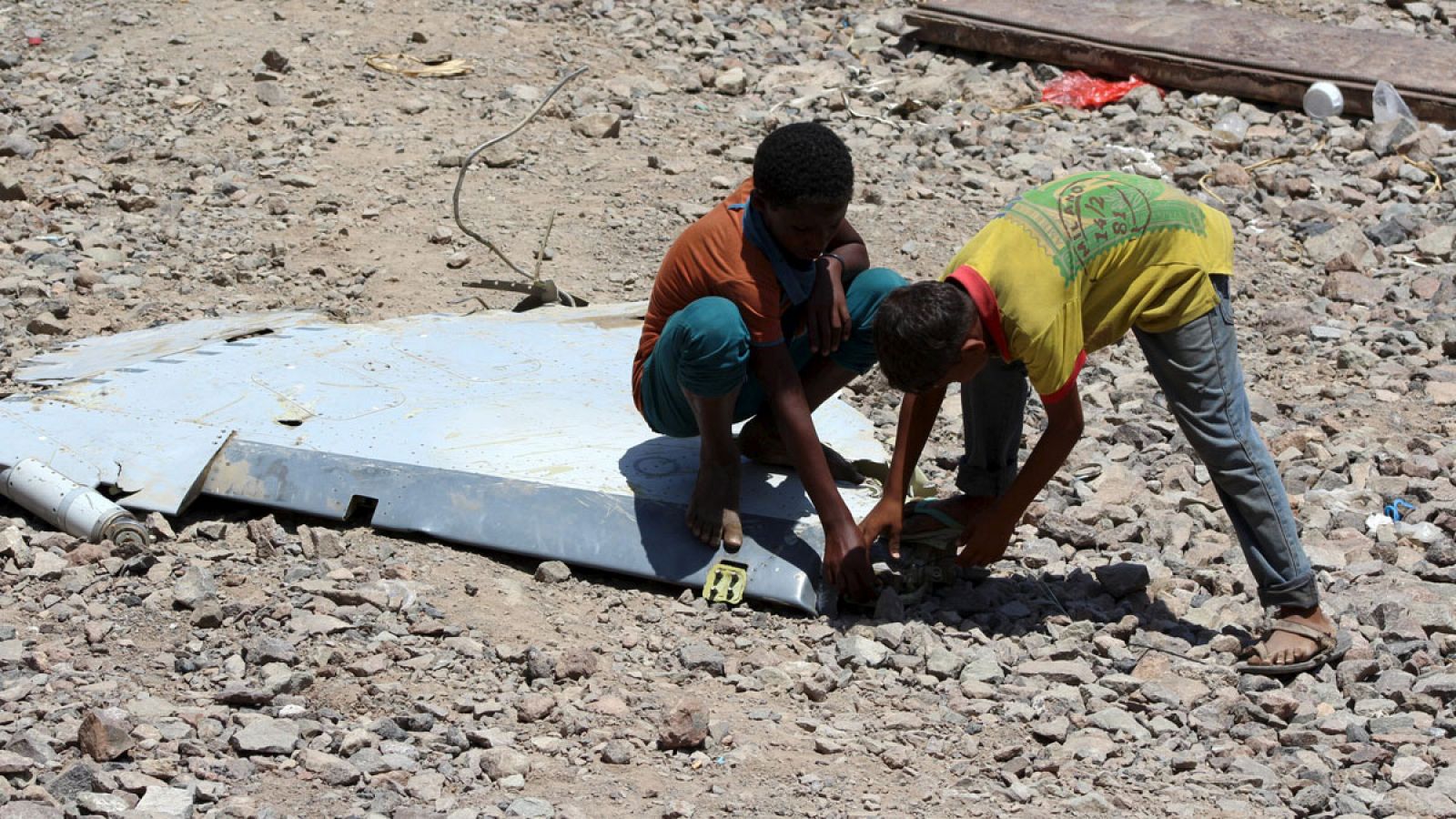 Dos niños yemeníes juegan con un trozo de fuselaje de un avión