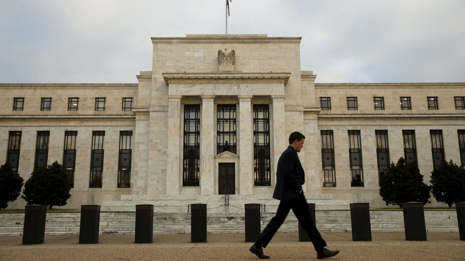 Un hombre camina delante de la sede de la Reserva Federal en Washington