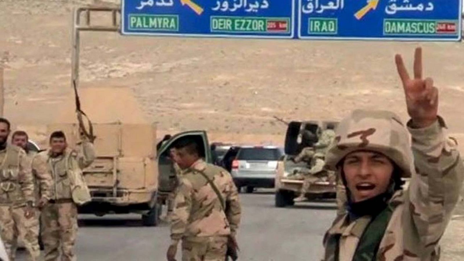 Soldados del régimen sirio saludan mientras se encaminan a Palmira