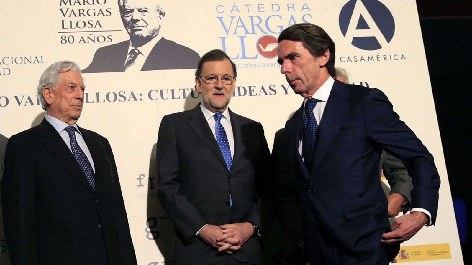 José María Aznar (i) pasa por delante de Mariano Rajoy (c) en un seminario sobre Vargas Llosa (i)