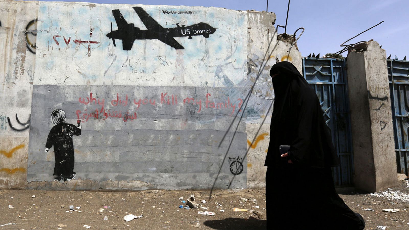 Una mujer camina junto a unas pintadas en contra de los drones estadounidenses y los ataques de EE.UU. contra supuestas pociones de Al-Qaeda en Saná, Yemen