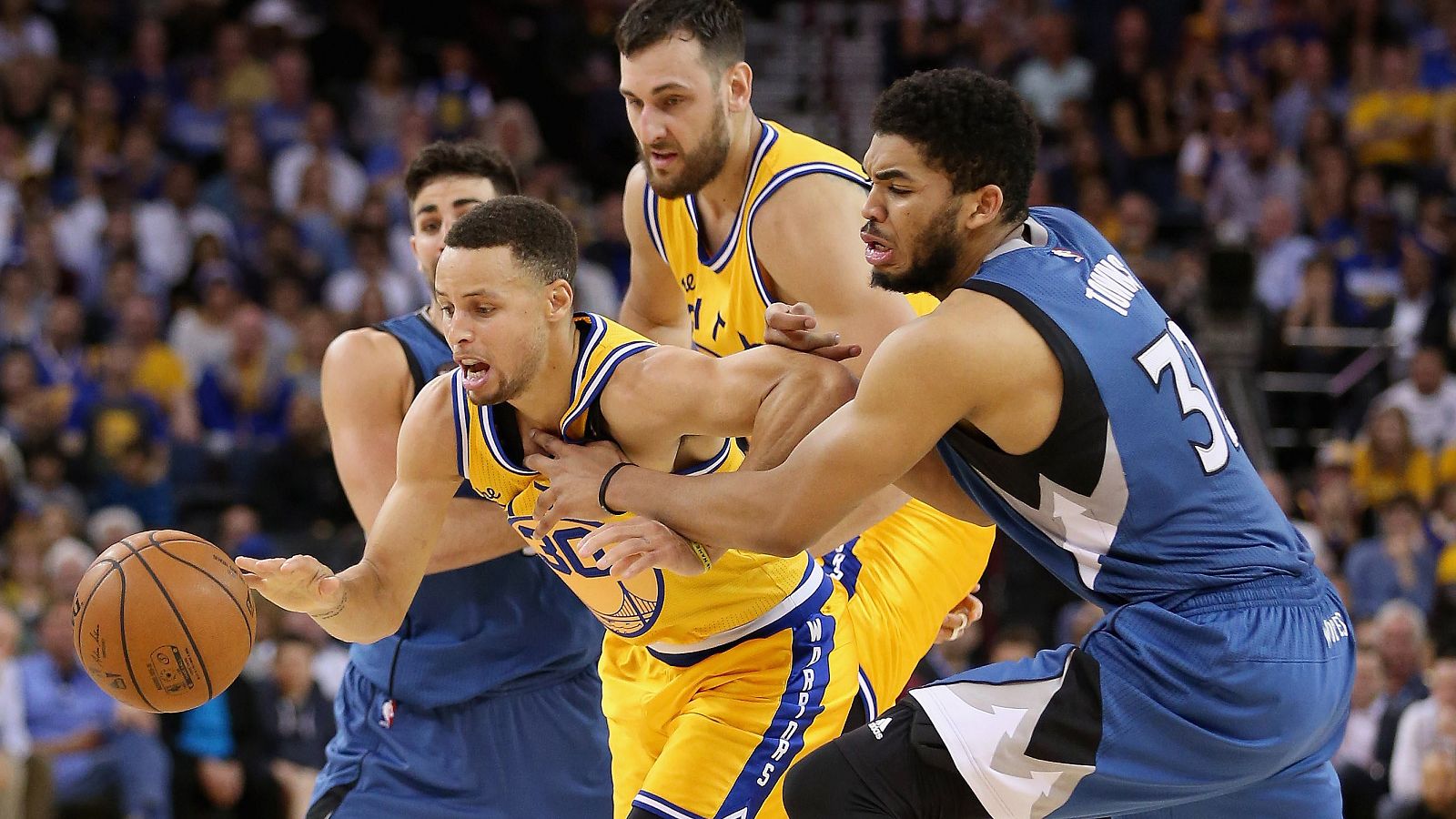 Curry trata de zafarse de la defensa de Ricky Rubio y Karl-Anthony Towns.