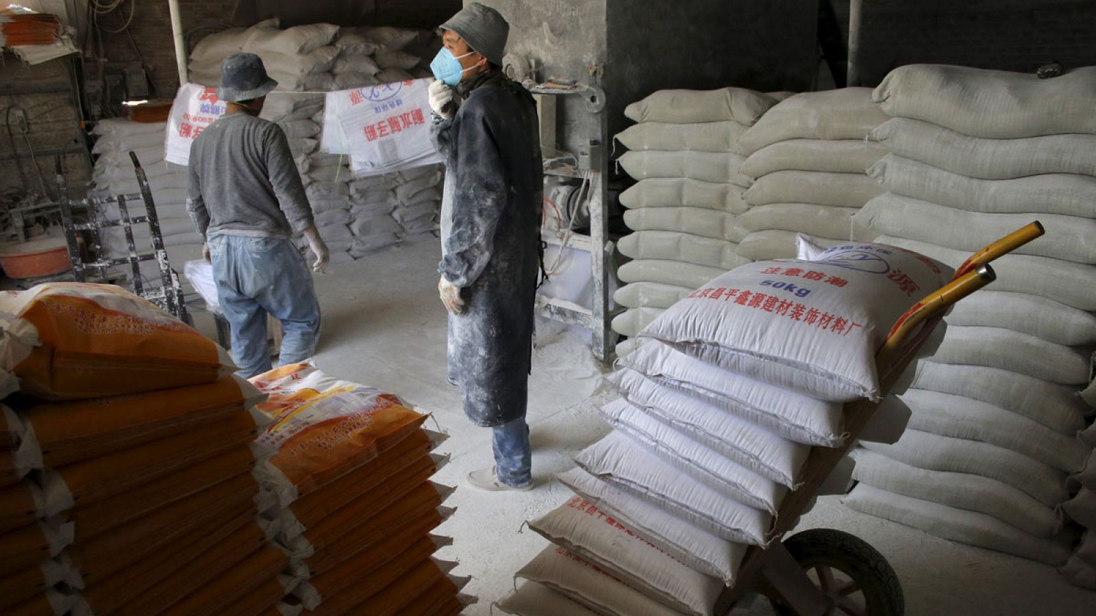 Obreros trabajando en una pequeña fábrica productora de masilla en una zona industrial en Pekín ,China.