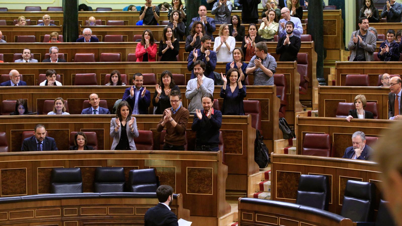 Los diputados de Podemos aplauden a su portavoz tras intervenir sobre el voto exterior.