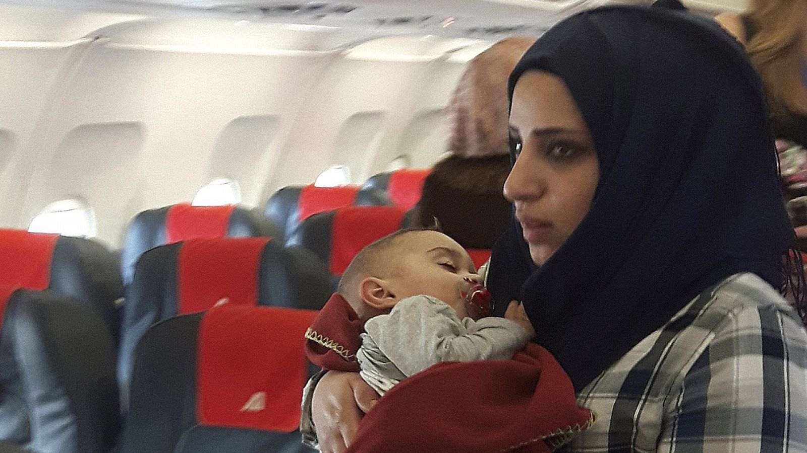 Refugiados sirios en el interior del avión que les ha llevado a Roma en el 'pasillo humanitario' de San Egidio