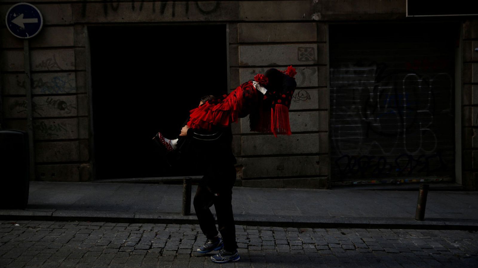 Un hombre traslada un maniquí vestido de flamenca por las calles de Madrid