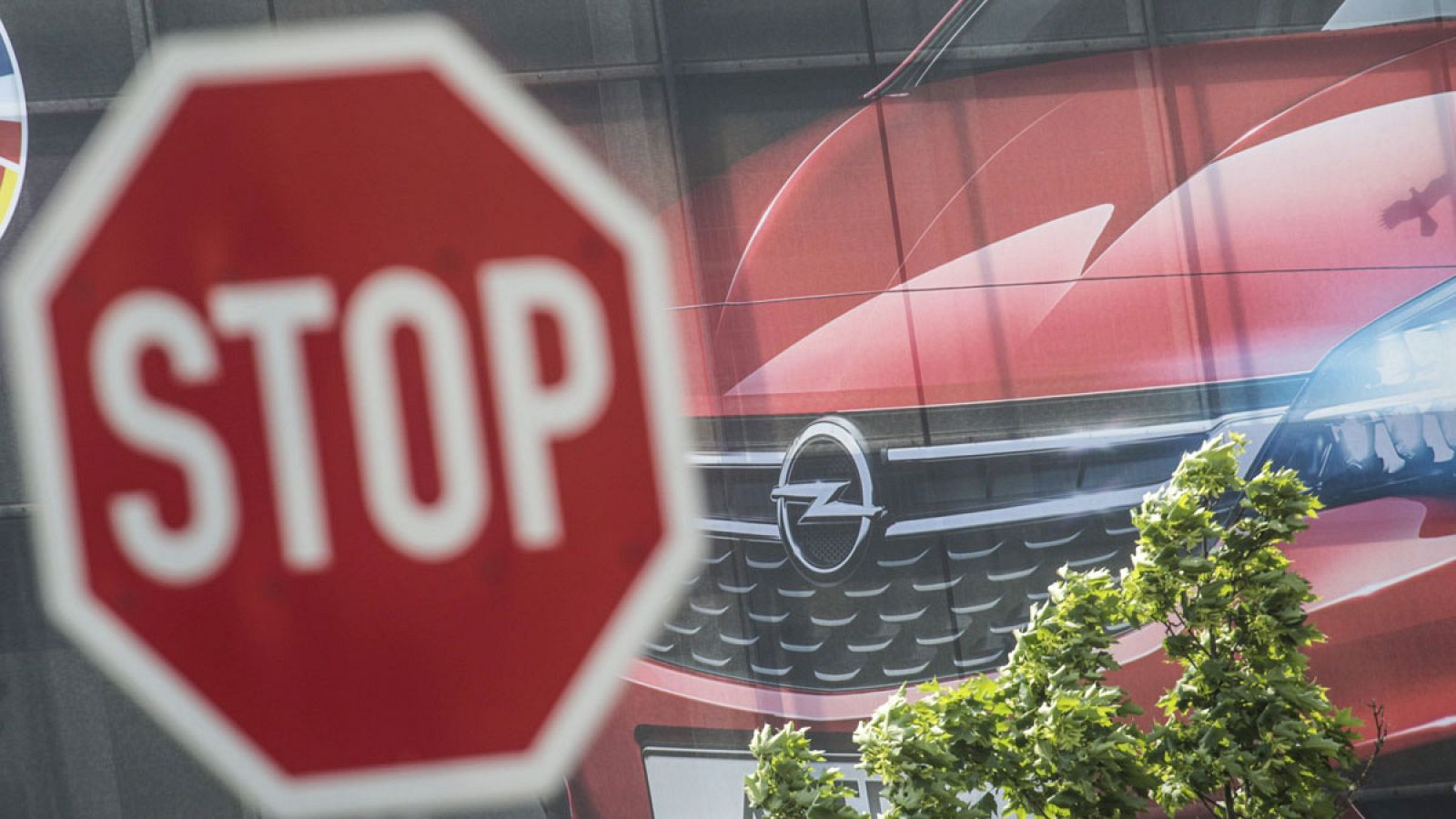 Una señal de Stop frente a un cartel publicitario de Opel