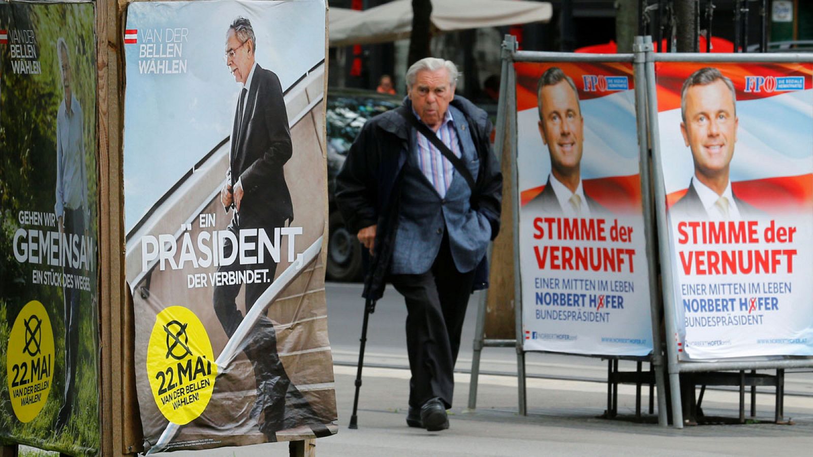Un hombre pasa junto a varios carteles electorales en Austria