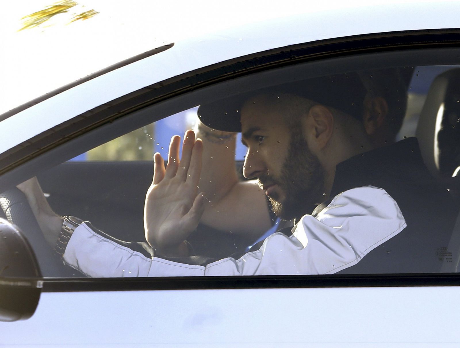 El delantero francés del Real Madrid Karim Benzema saluda a su llegada esta mañana a la Ciudad Deportiva de Valdebebas.