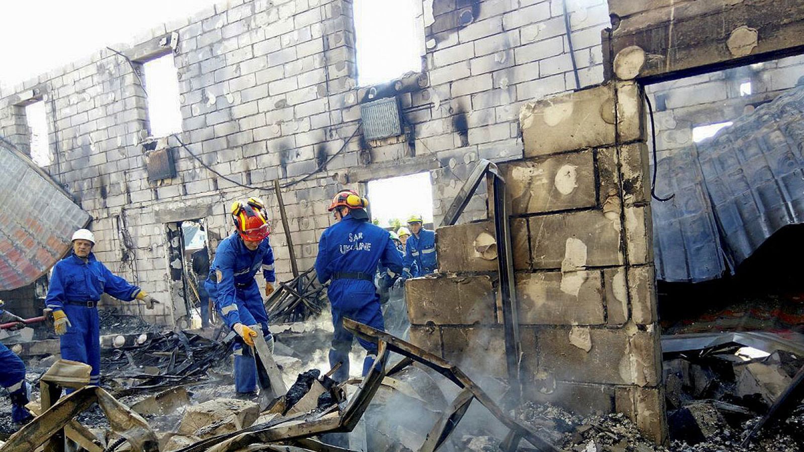 Los equipos de rescate trabajan en el edificio incendiado en Litochki, Ucrania