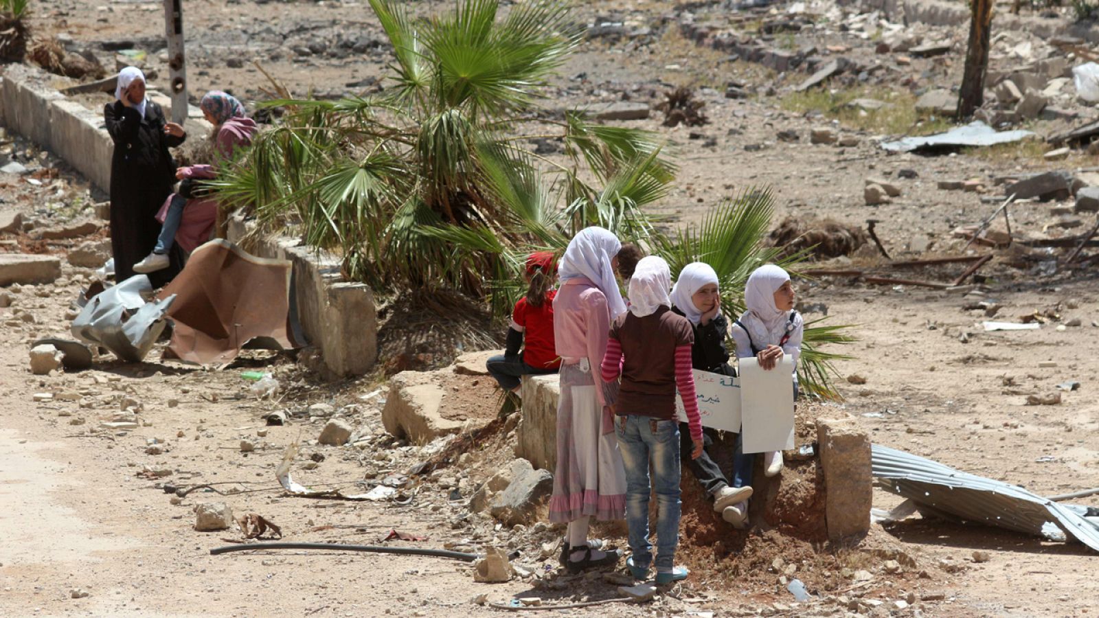 Mujeres sirias sujetan carteles en la ciudad de Daraya