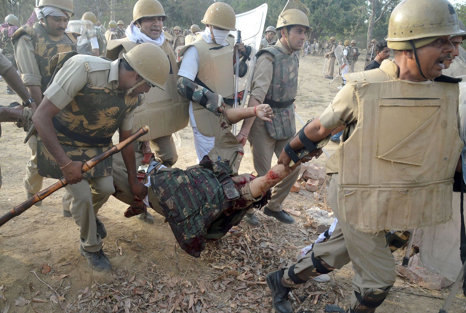 Policías indios evacúan a un compañero herido en los enfrentamientos de Mathura