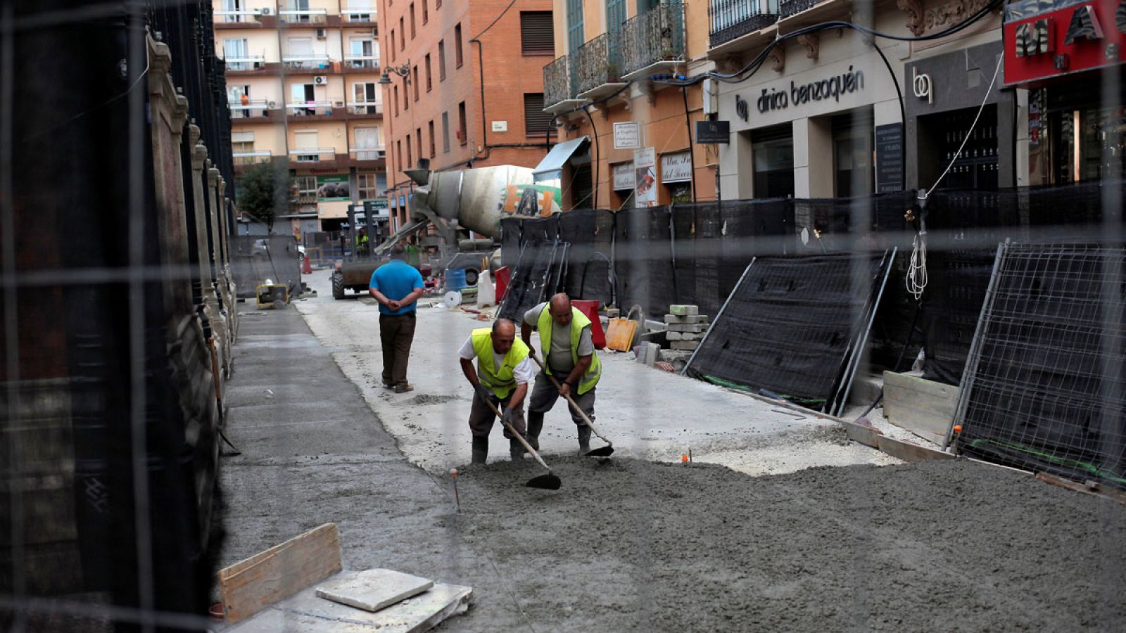 Unos obreros extienden una capa de hormigón en una calle de Málaga