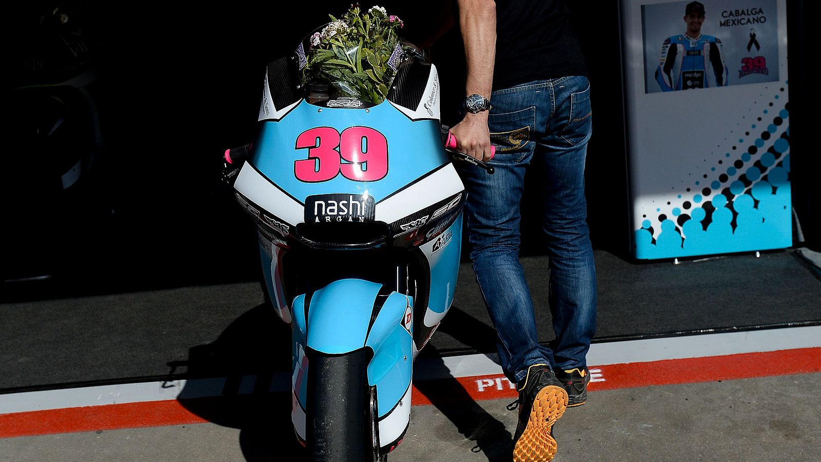 La moto de Luis Salom, con un ramo de flores.