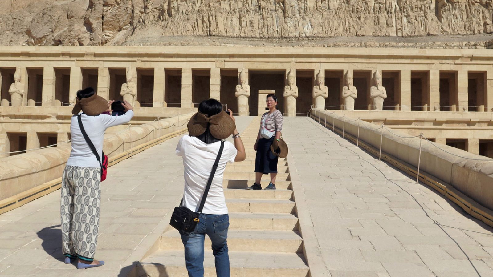 Turistas de nacionalidad china se hacen fotos frente al templo de Hatshepsut, en Luxor
