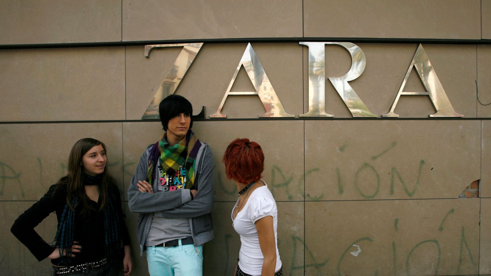 Tres jóvenes charlan en el exterior de una tienda de Zara en Sevilla