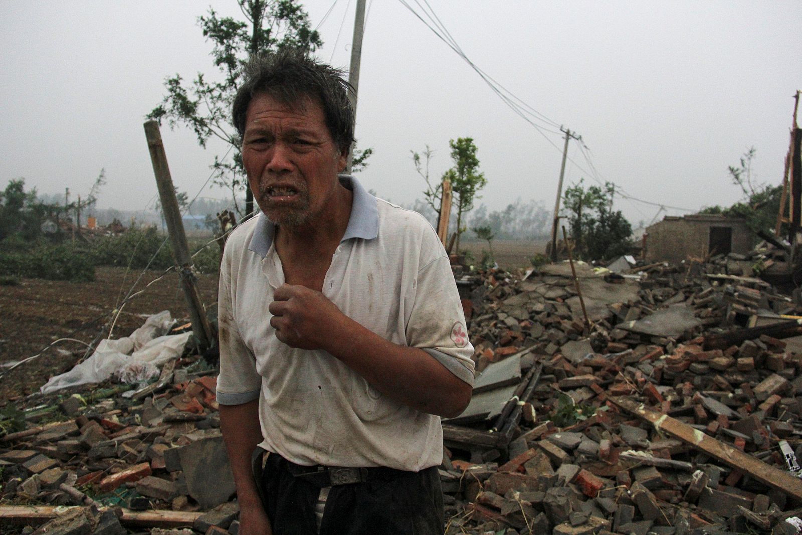 Un hombre camina entre el desastre que estan dejando las fuertes lluvias en Yangcheng.