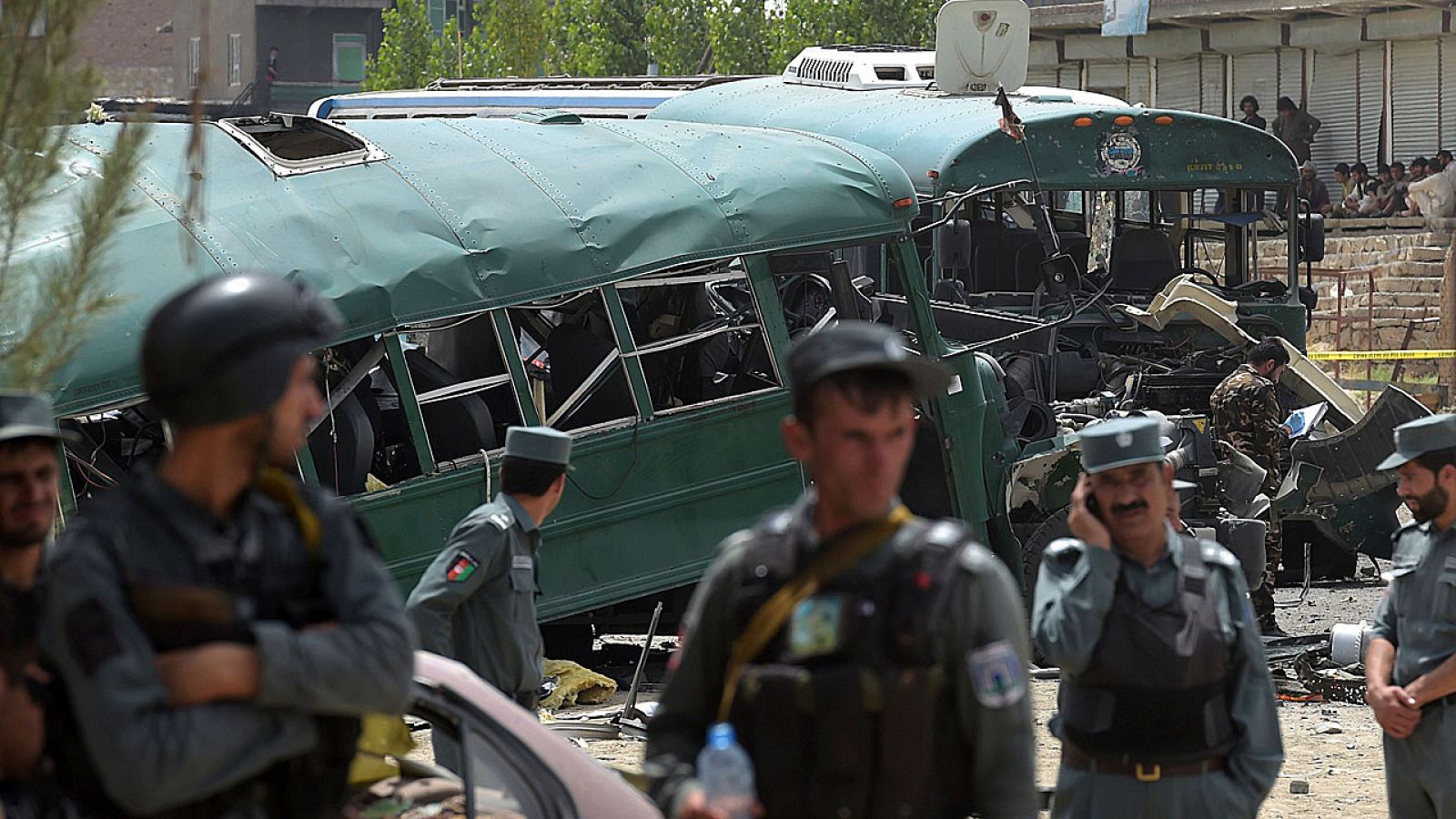 Personal de seguridad afgano se acerca al autobús calcinado en un atentado talibán en Kabul.