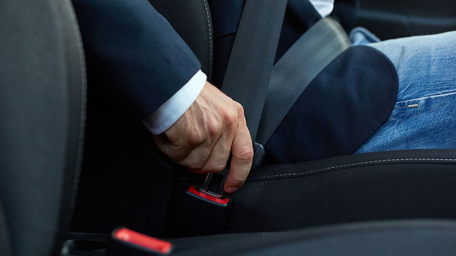 Un conductor se abrocha el cinturón de seguridad de su vehículo