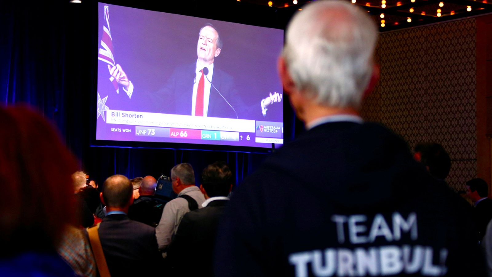Un votante del los conservadores del primer ministro Malcom Tumbull sigue la rueda de prensa del líder laborista Bill Shorten.
