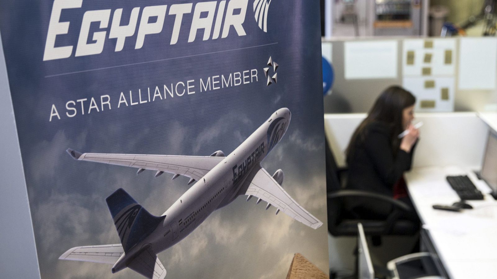 Una azafata habla junto al mostrador de la aerolínea Egyptair.