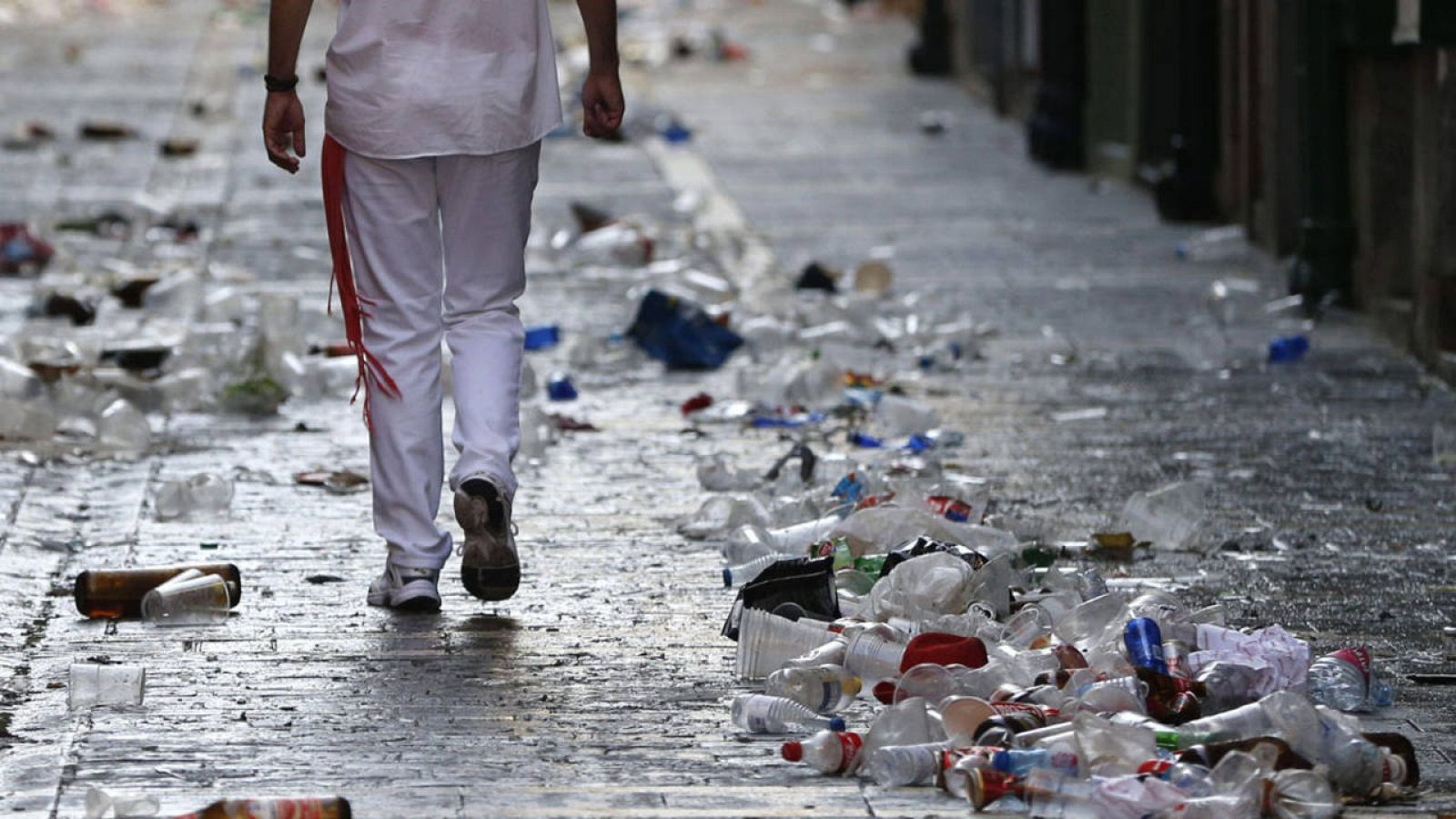Un mozo camina entre los desperdicios durante la celebración de San Fermín en 2015
