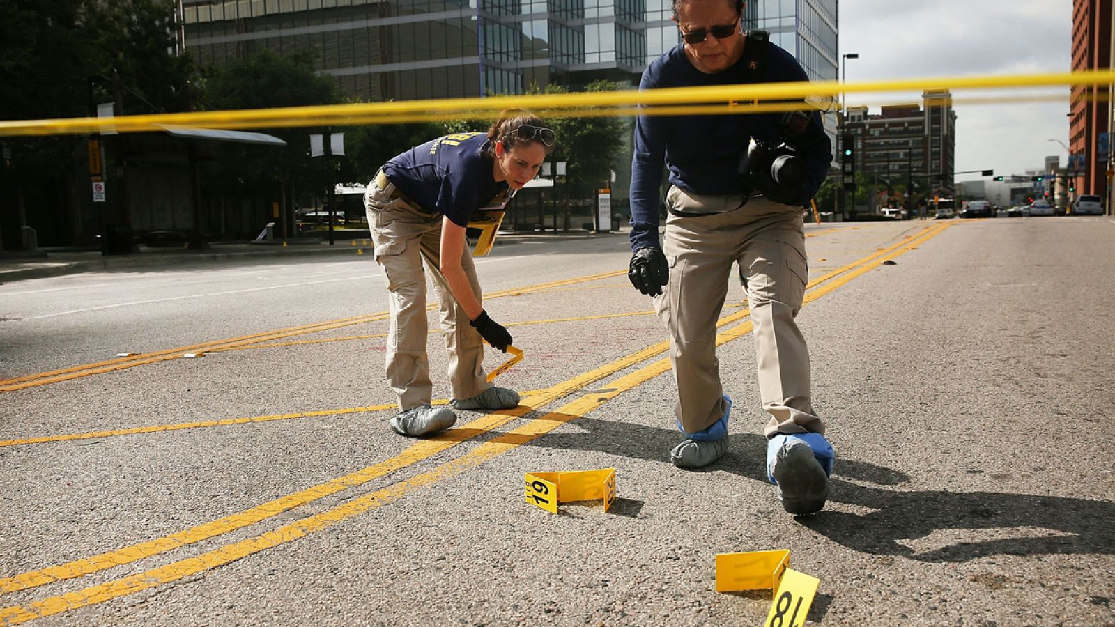 Miembros del FBI rastrean el área de la escena del crimen de Dallas.