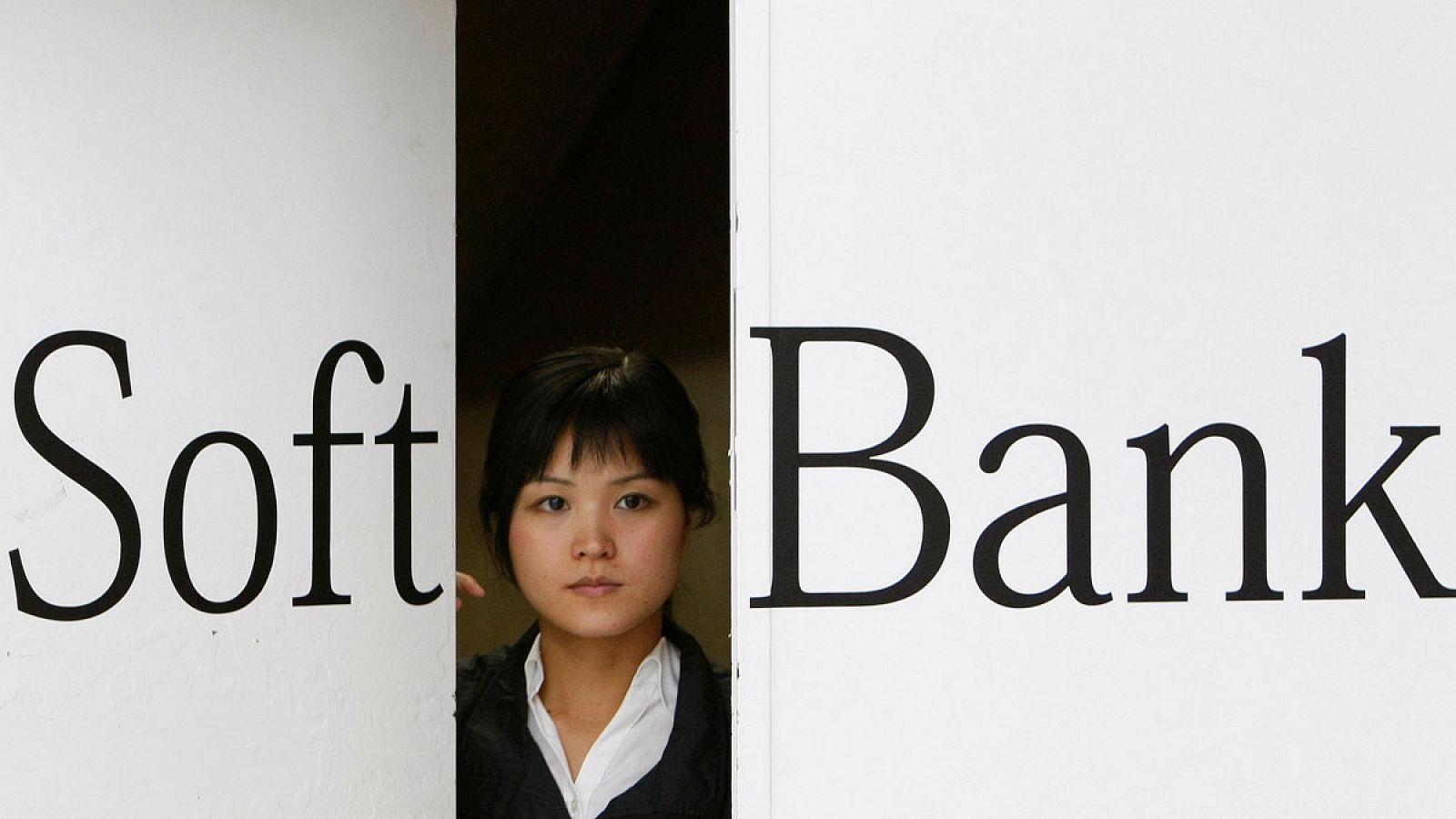Una dependienta abre una puerta con el logo de Softbank