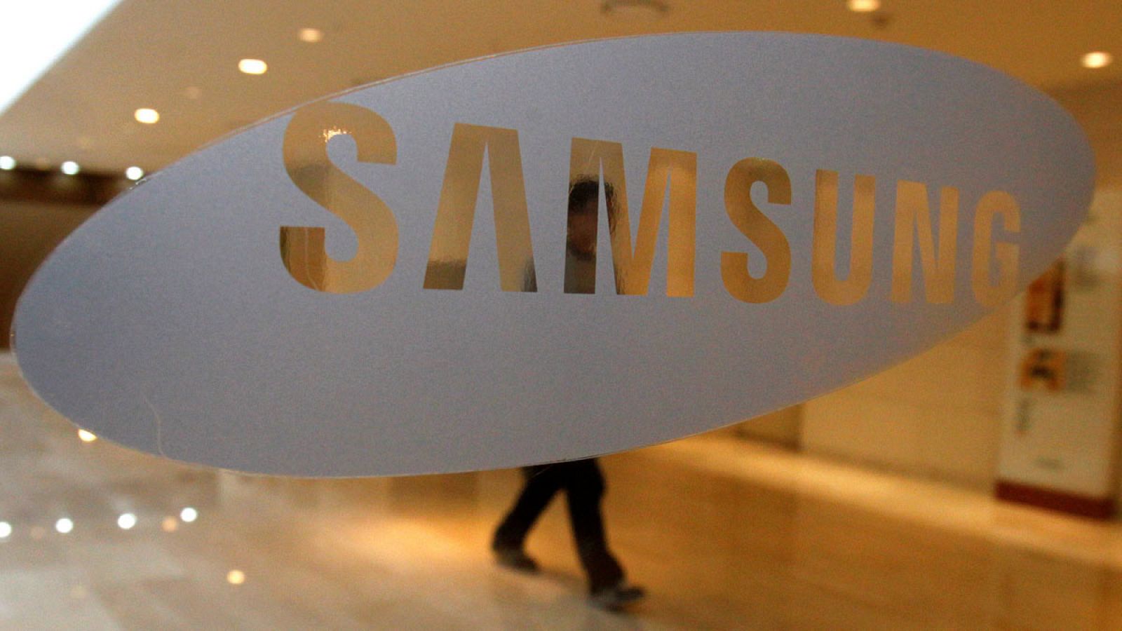 Un hombre camina detrás de un logotipo de Samsung Electronics en la sede de la compañía en Seúl.