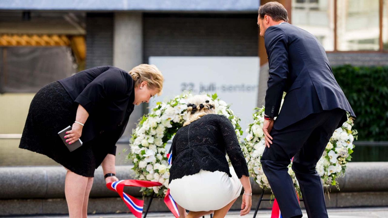 El primer ministro noruego, Erna Solberg (izquierda), la princesa Mette-Marit (centro) y el pr&iacute;ncipe Haakon (derecha) depositan una ofrenda florar durante una ceremonia en la sede del gobierno de Oslo este viernes.