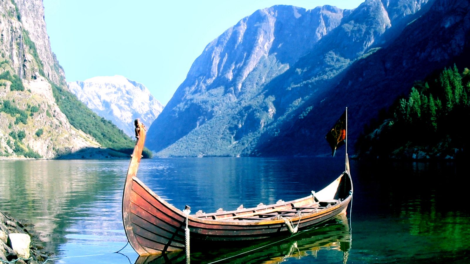 Imagen de un drakkar fondeado en un fiordo noruego.