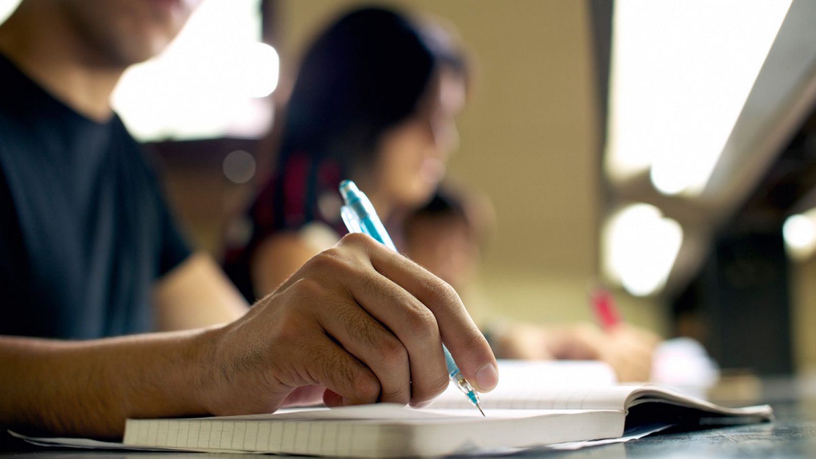 Un estudiante toma notas en clase