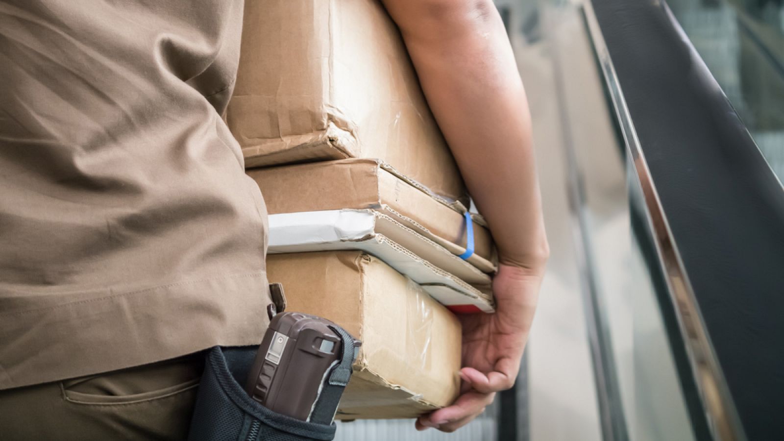 Un trabajador de una empresa de mensajería carga varios paquetes