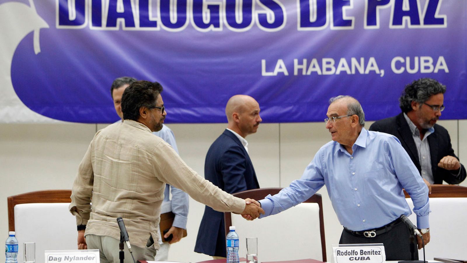 El comandante de las FARC, Luciano Marín (i), alias Iván Márquez, estrecha la mano del jefe negociador del Gobierno colombiano, Humberto de la Calle (d).