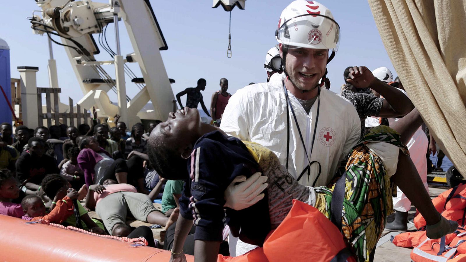 Un miembro de la Cruz Roja italiana asiste a una migrante durante una operación de rescate frente a Libia