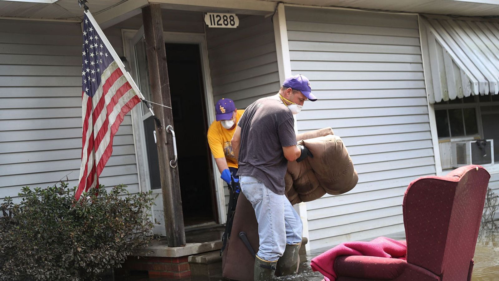 Dos personas retiran de una casa los muebles y objetos dañados tras las inundaciones que han afectado el estado de Luisiana.