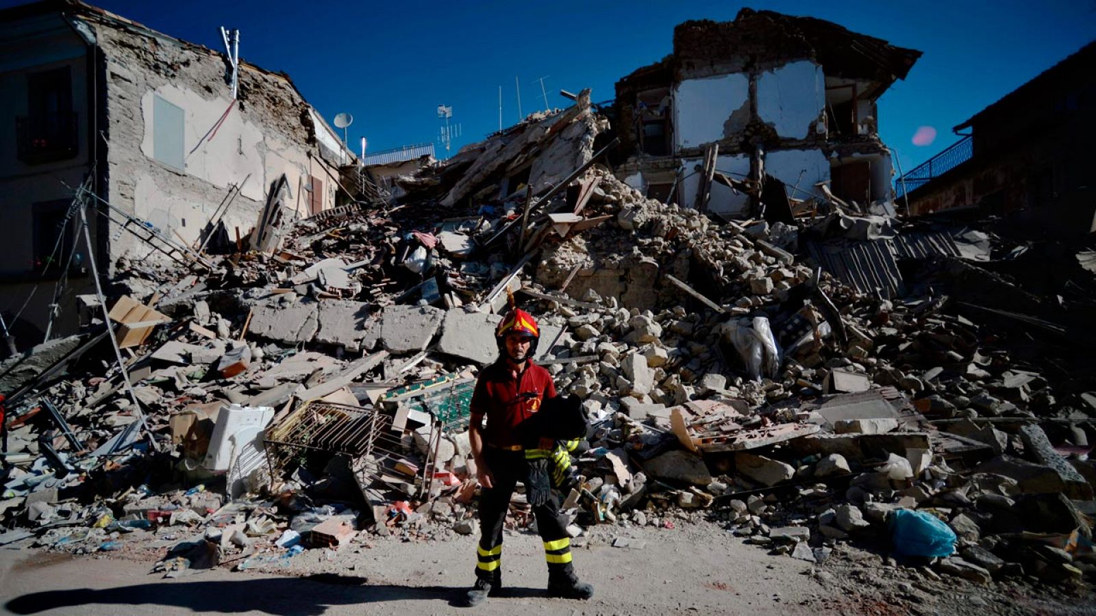 Un bombero se toma un respiro en Amatrice, el pueblo más afectado por el terremoto del centro de Italia