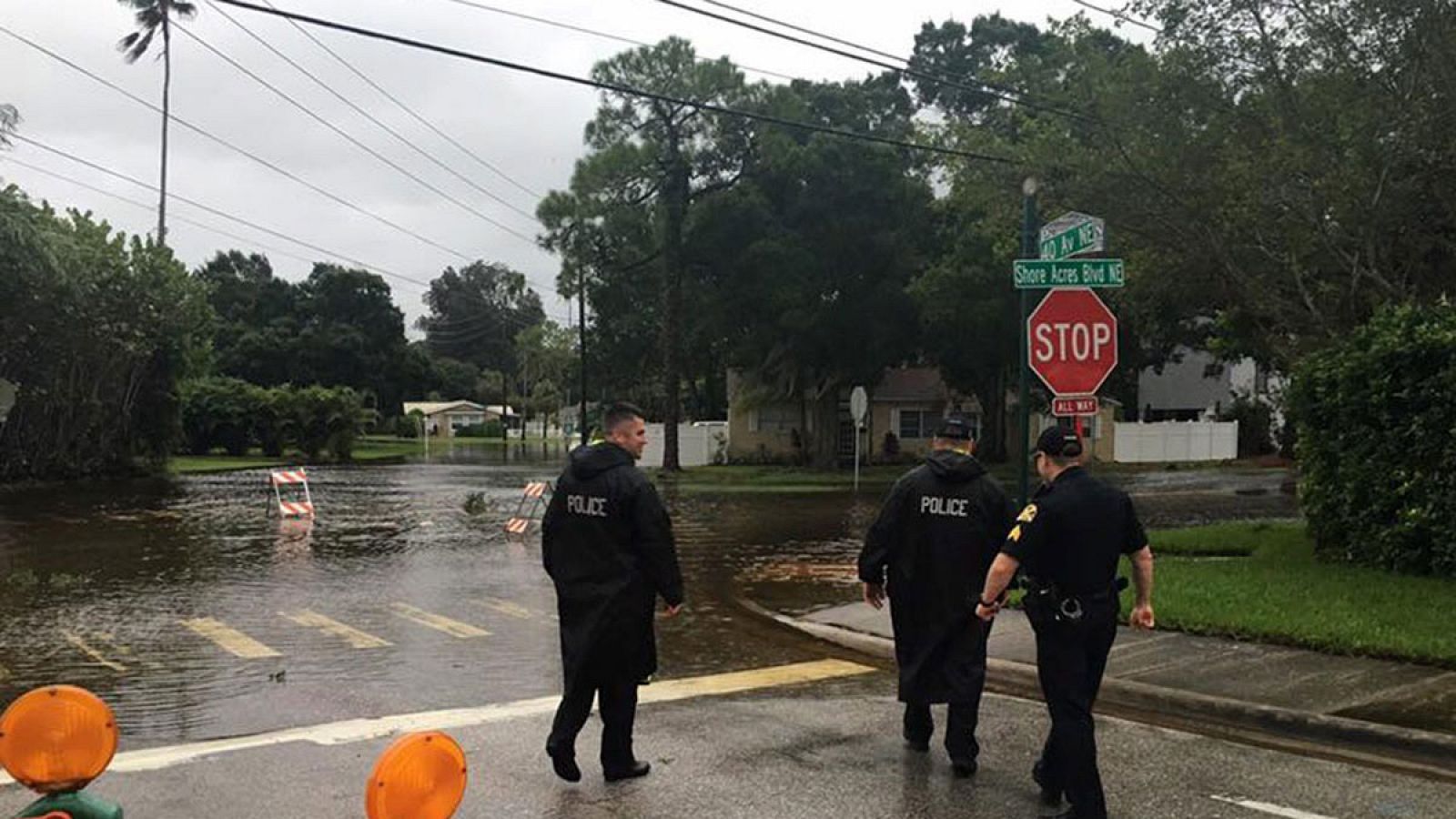 Policías locales observan una carretera inundada en un barrio de  St. Petersburg, Florida.
