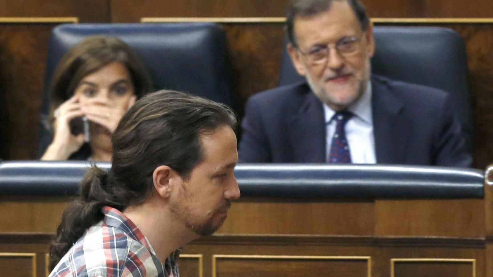 El líder de Podemos, Pablo Iglesias, pasa por delante del presidente en funciones, Mariano Rajoy