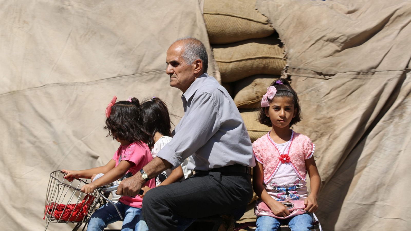 Un hombre transporta a tres niñas en la ciudad siria de Qamishli durante la tregua patrocinada por EE.UU. y Rusia