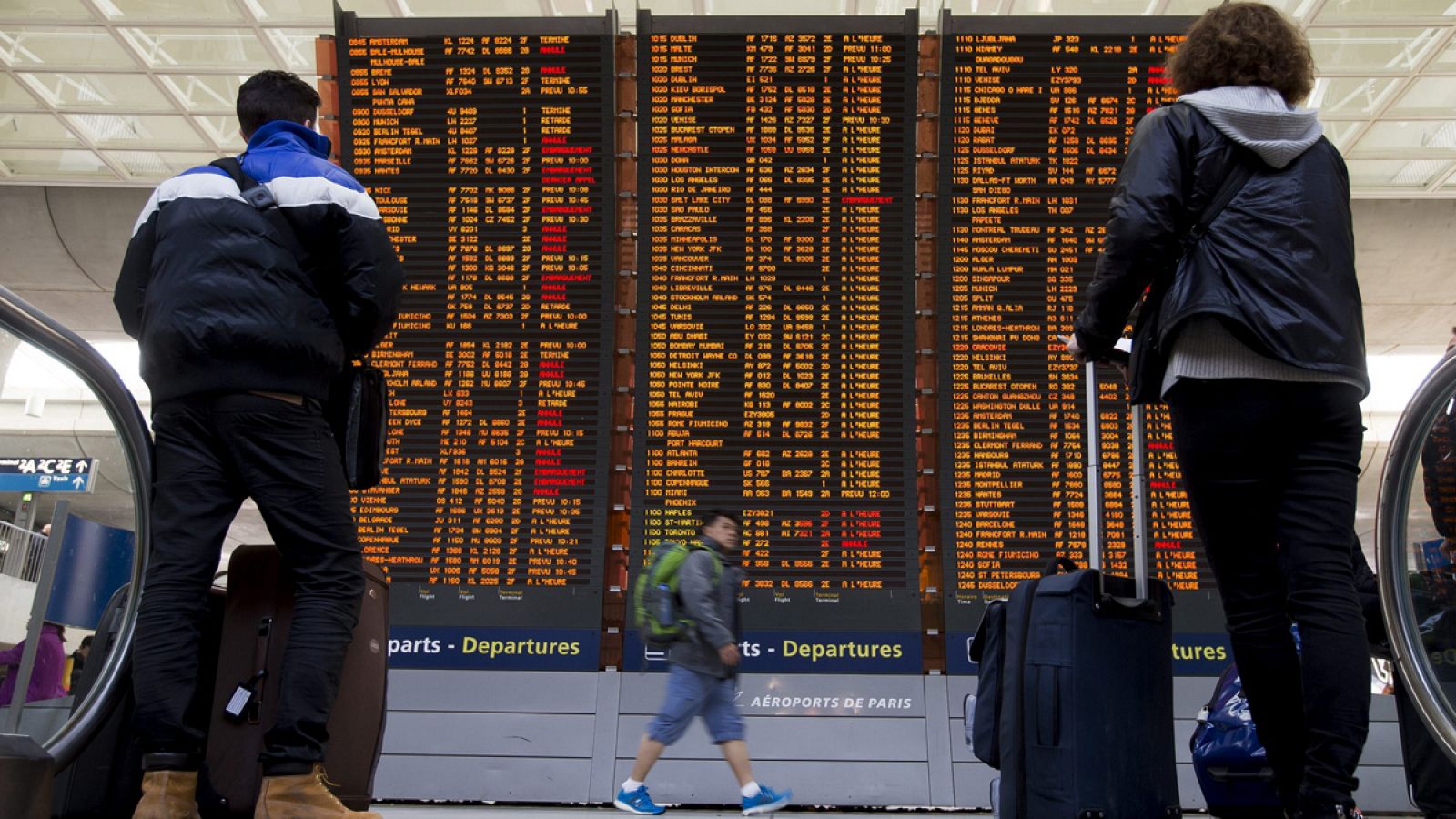 Dos viajeros comprueban la información de los vuelos en las pantallas del aeropuerto Charles de Gaulle, en Roissy, Francia