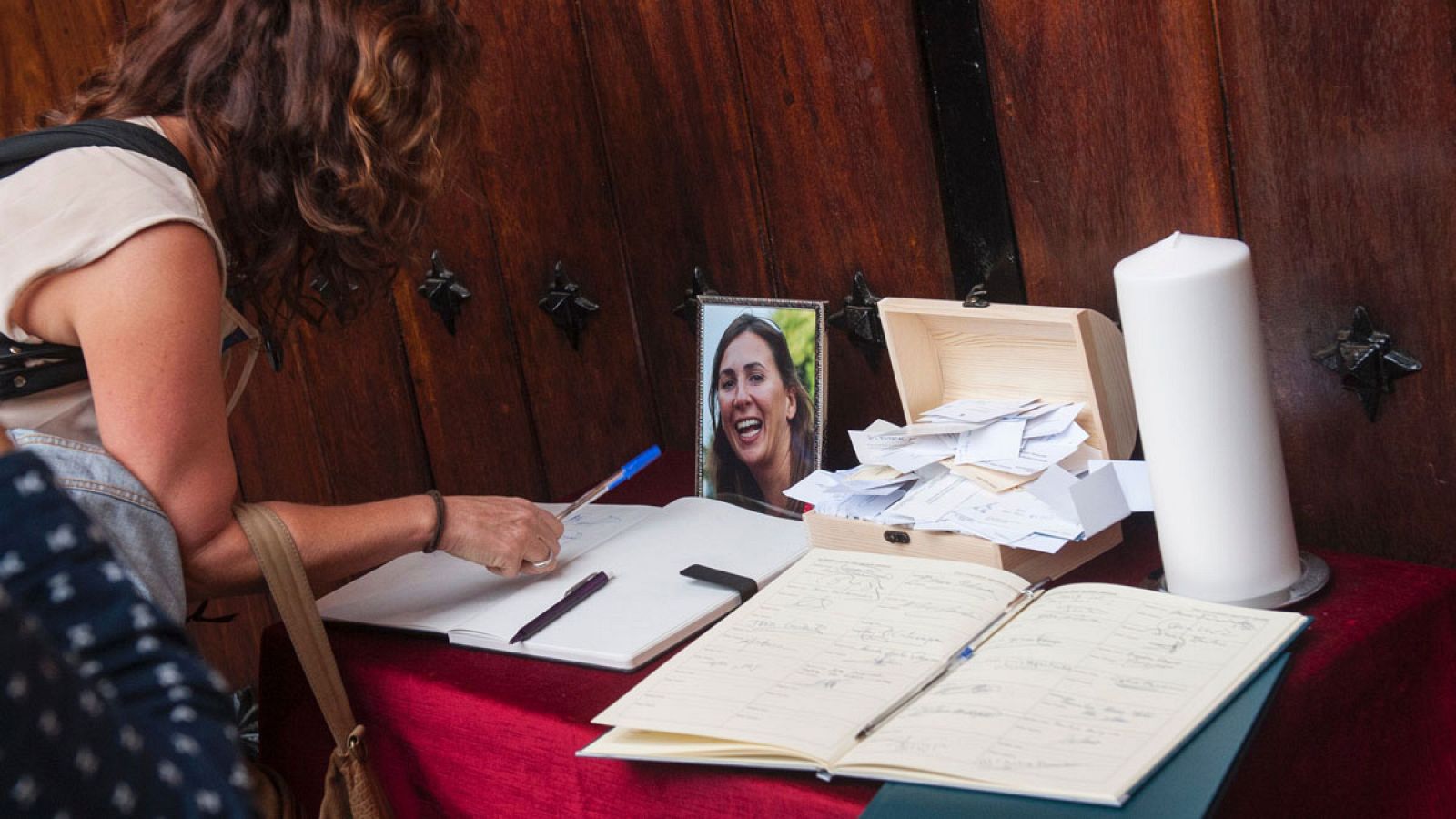 Una mujer firma en el libro de condolencias durante el funeral de Maria Villar