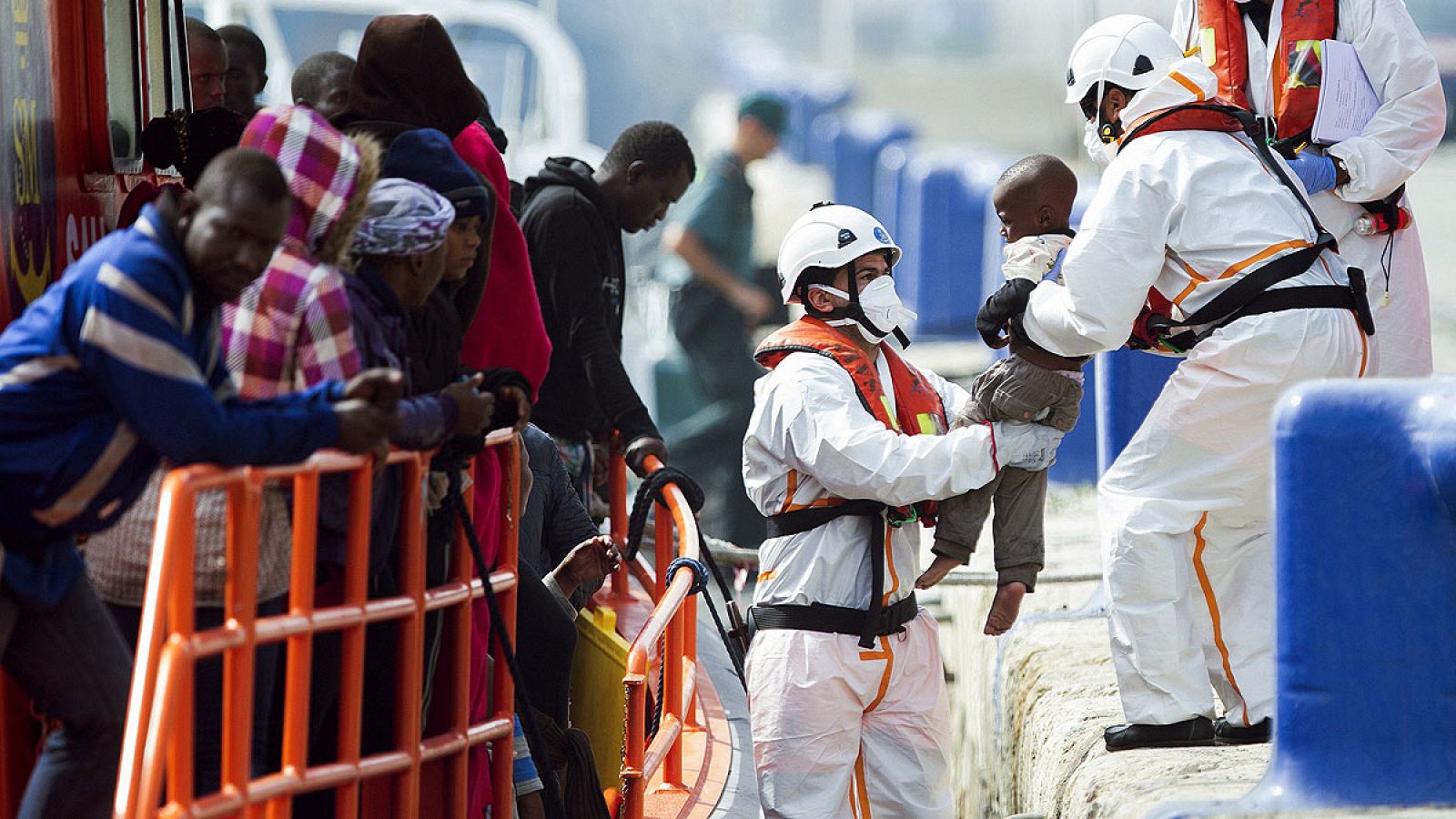 Efectivos de Salvamento Marítimo sostienen a uno de los bebés rescatados en una patera en el mar de Alborán