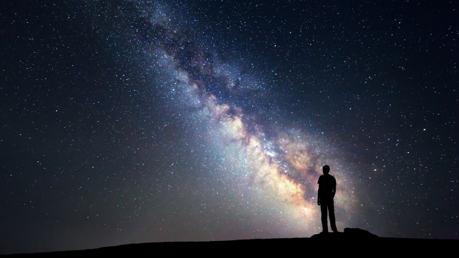 Un hombre observa la Vía Láctea, la galaxia espiral donde se encuentra el sistema solar.