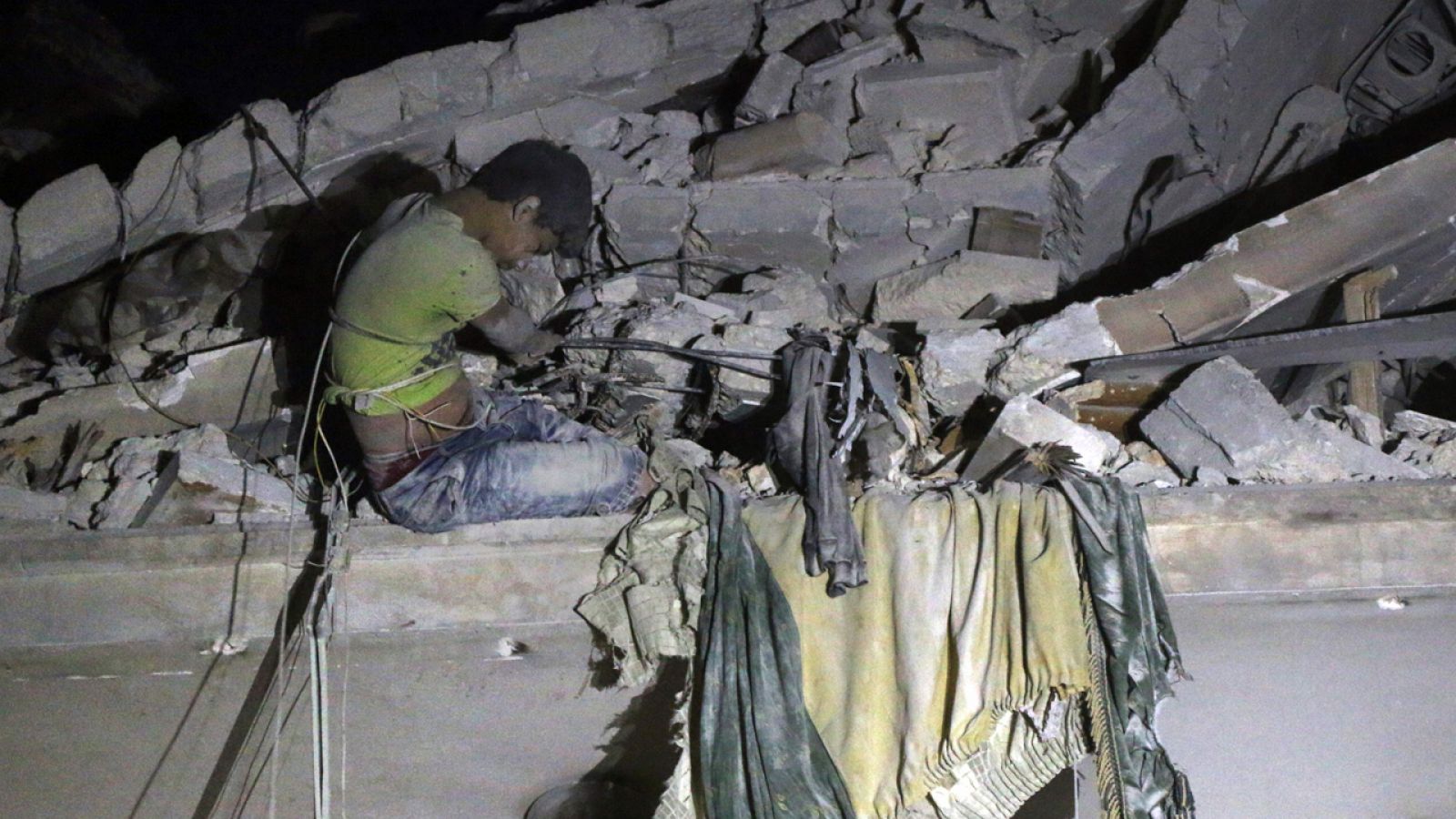 Maaruf, un niño sirio de 12 años, espera su rescate atrapado en el desplome de su casa en Alepo tras un bombardeo aéreo