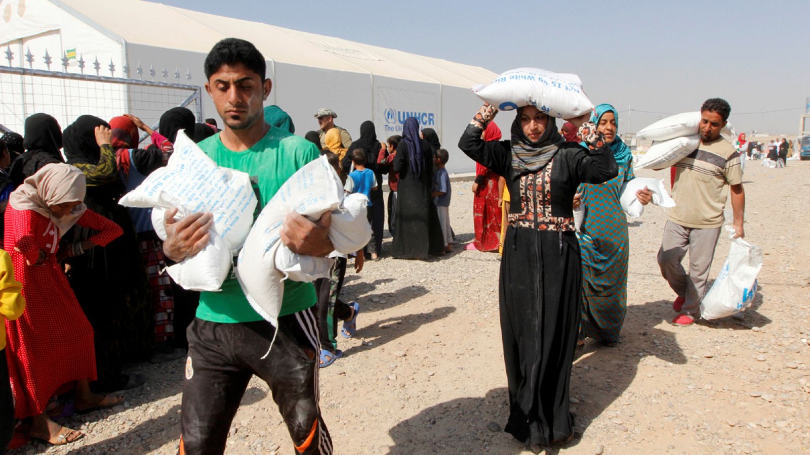 Personas que huyeron de Mosul y Hawija, tomadas por el Estado Islámico, reciben ayuda en un campo para desplazados en Daquq, Irak.